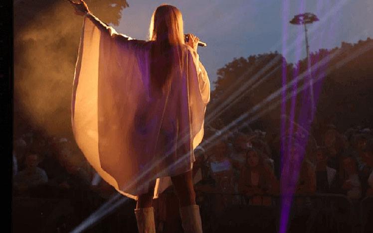 Singer performing in front of a crowd at Fontwell Park Racecourse.