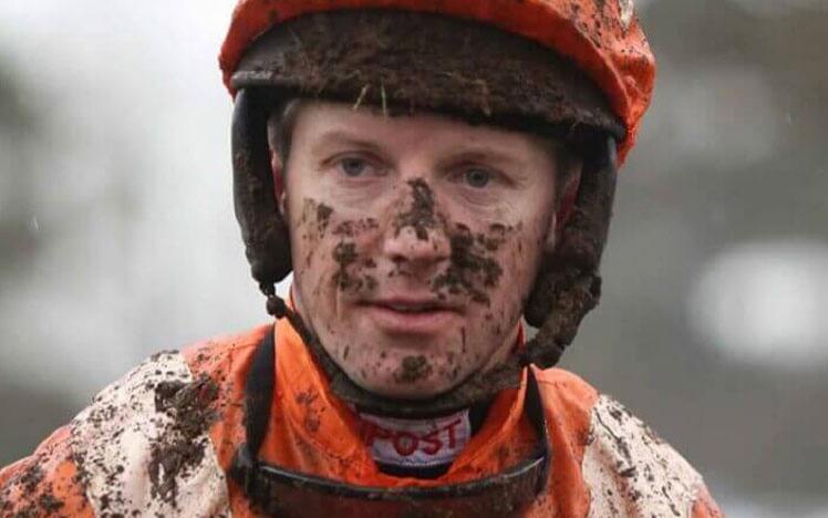 Jockey covered in mud after racing.