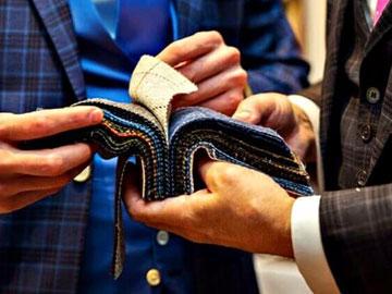 Two gentlemen looking through a cloth samples.
