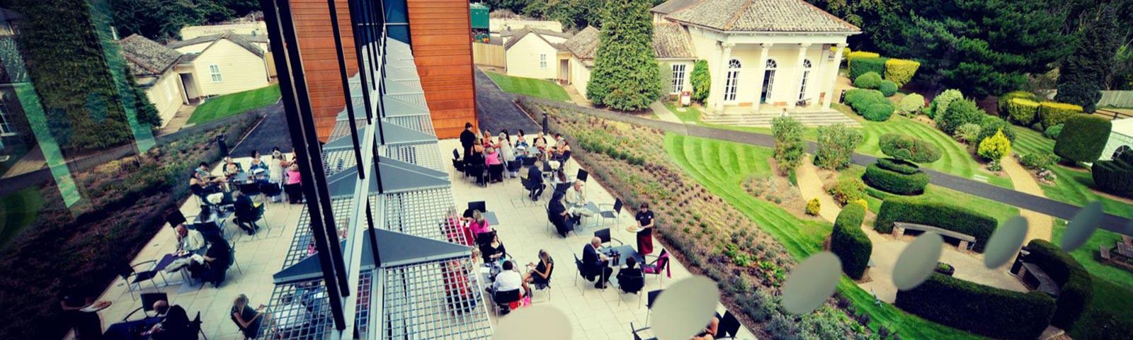 People sitting on a terraced area of the grandstand at Fontwell Park Racecourse.
