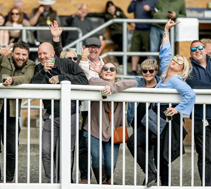 A group of race goers pul a fun pose for the camera at Fontwell Park