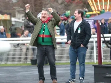 A race goer in a Christmas jumper cheers at Fontwell Park