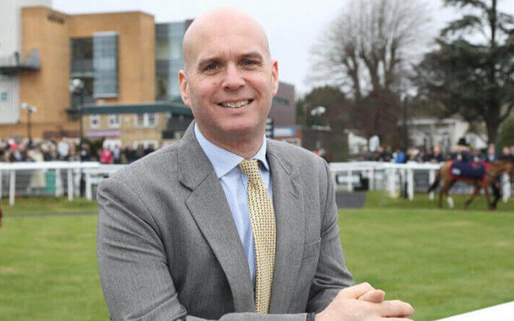 Jonathan Acott posing for a photo with Fontwell Park Racecourse in the background.